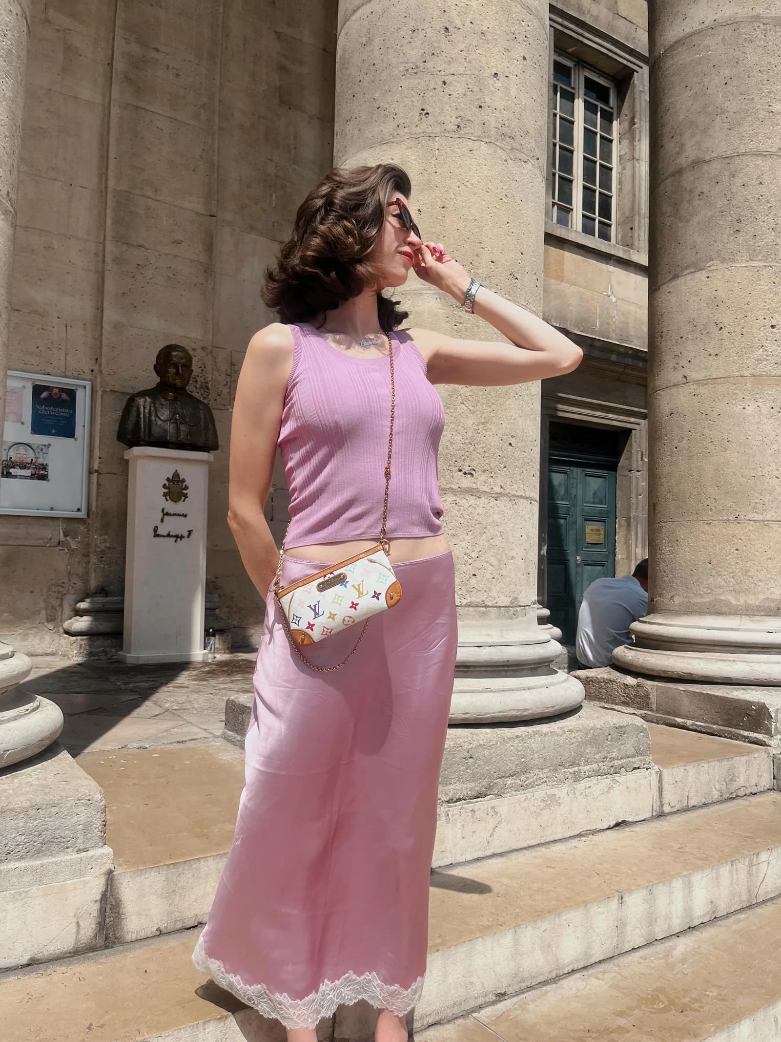 Sierra “Sisi” Moses in a pink outfit standing beside stone columns